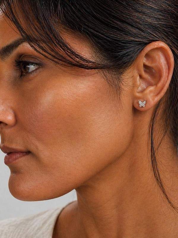 A woman wearing ANNA & LUC butterfly earrings